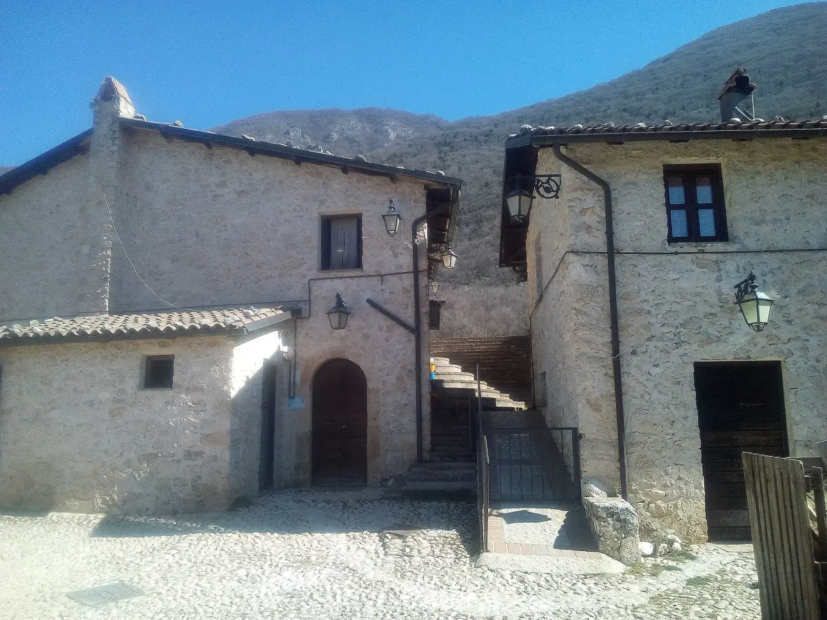 Antiche case in pietra con un portone ad arco nella frazione montana di Cartore