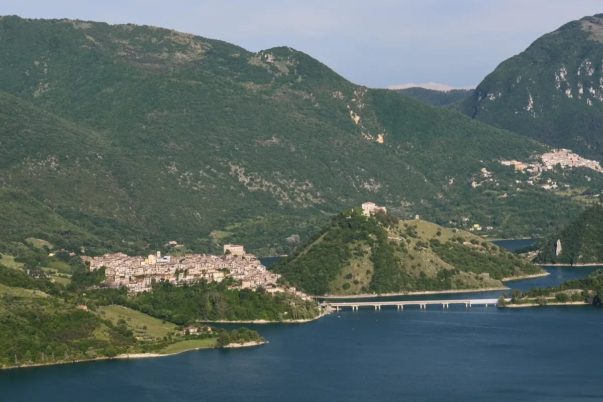 Castel di Tora sul pendio con il lago e un ponte sotto