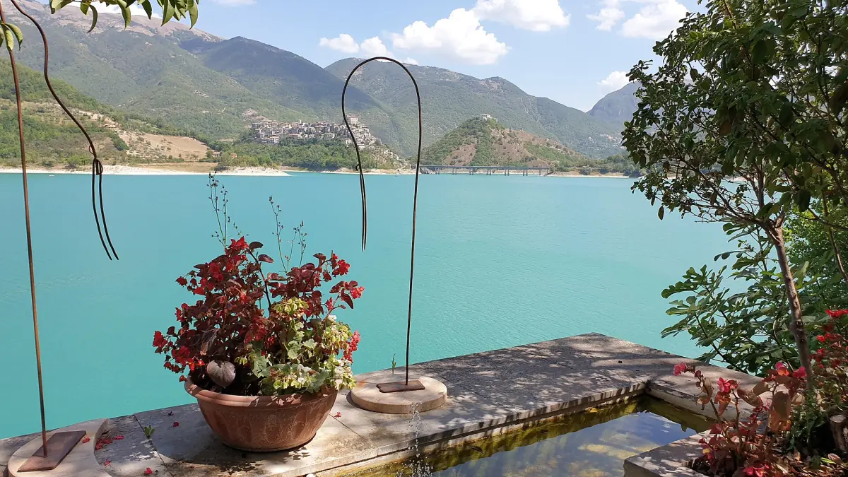 Vasi di fiori su un muretto di una terrazza sopra l'acqua turchese del lago