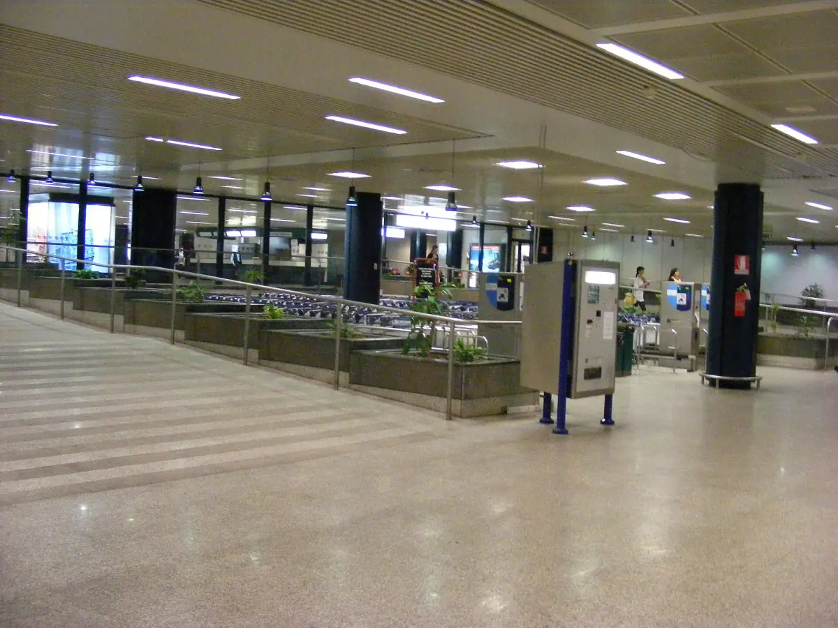 Sala arrivi dell'aeroporto di Roma Fiumicino con scale mobili e banchi