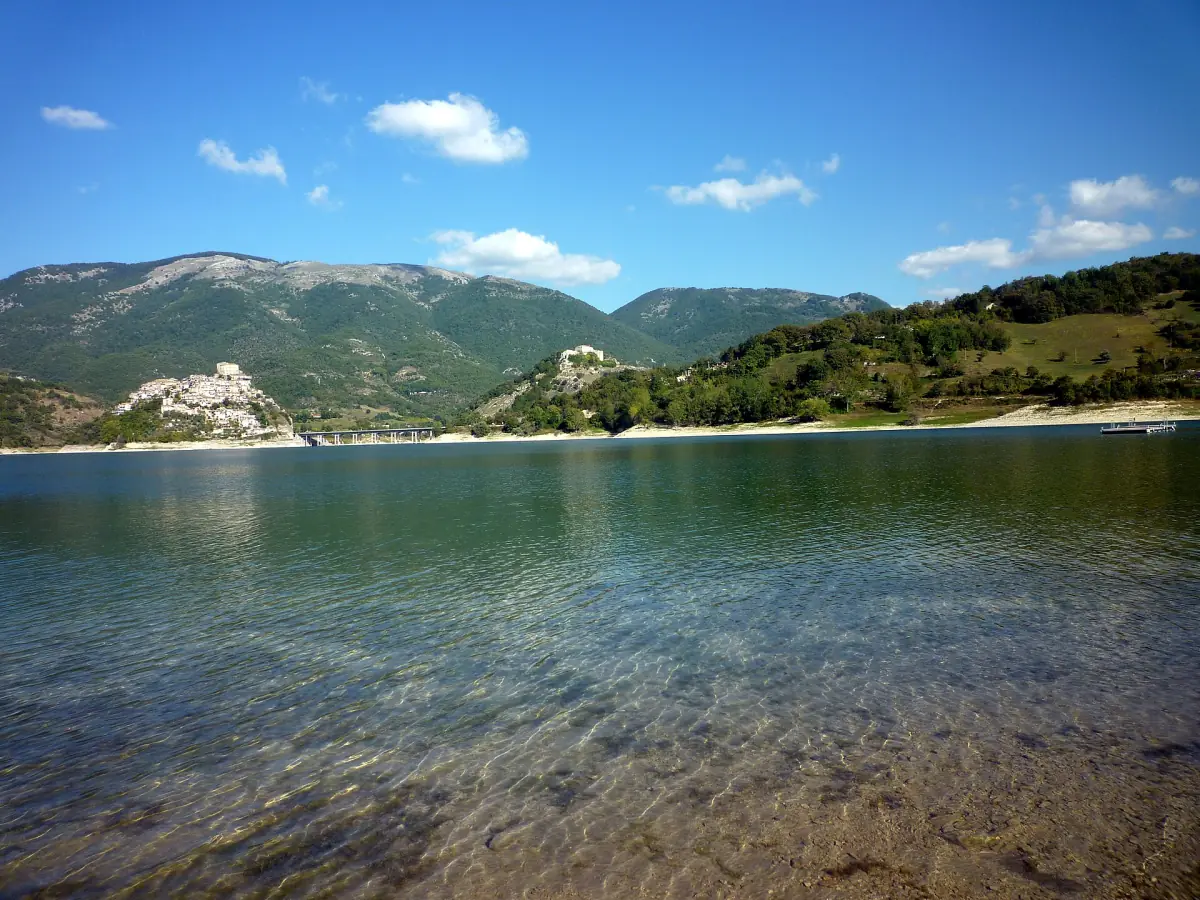 Acqua limpida e bassa del Lago del Turano con colline sulla riva opposta