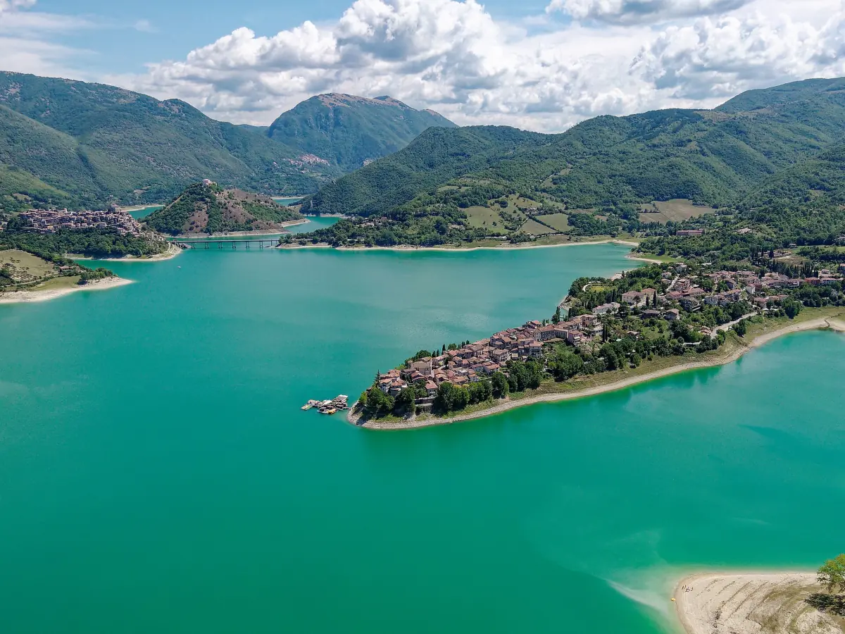 Veduta aerea del Lago del Turano turchese con un borgo su una penisola