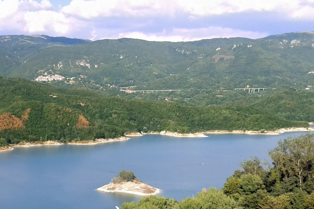 Lago del Salto con un piccolo isolotto e un borgo sul crinale sopra