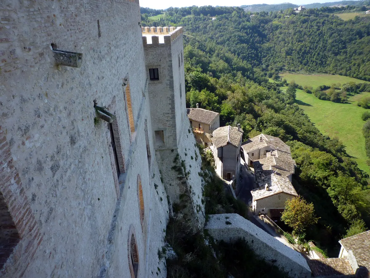 Torre del castello di Rocca Sinibalda con i tetti del borgo e la valle verde sotto